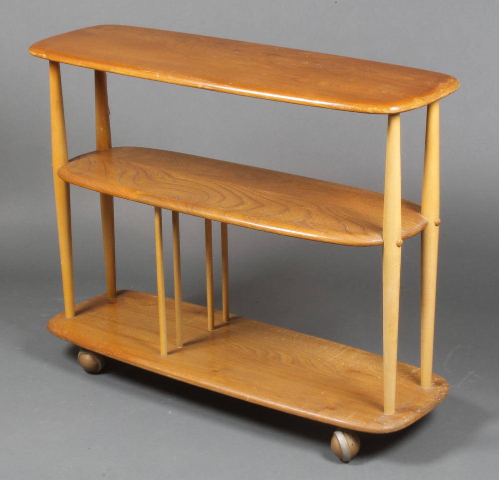 An Ercol oval light elm 3 tier tea trolley, raised on 23rd September