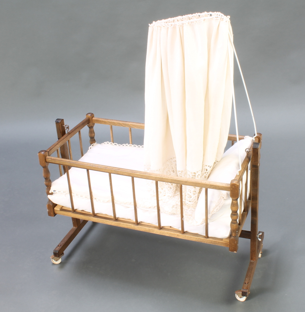 A child's toy rocking crib with canopy and turned 26th October 2016