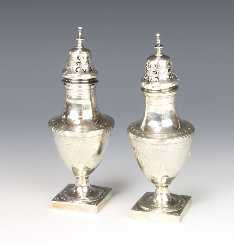 A pair of silver casters of urn shape on 15th August 2018
